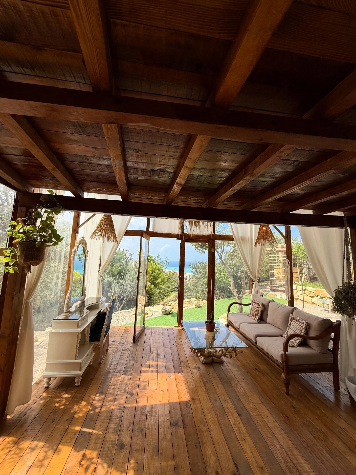 Sunlit lounge with wooden beams and mountain views
